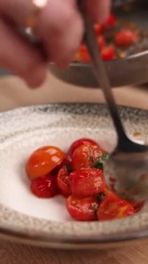 Şef mutfakta domatesli lezzetli bir yemek hazırlıyor. Yakın plan.