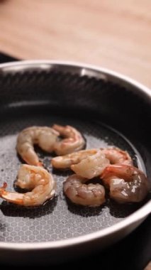 Bir şef mutfakta karides yemeği hazırlar. Yakın plan.