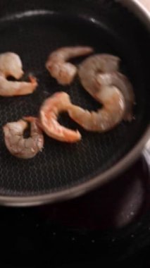 Bir şef mutfakta karides yemeği hazırlar. Yakın plan.