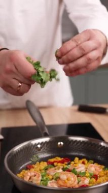 Bir şef mutfakta karides yemeği hazırlar. Yakın plan.