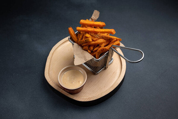 Картошка фри с соусом на деревянной доске