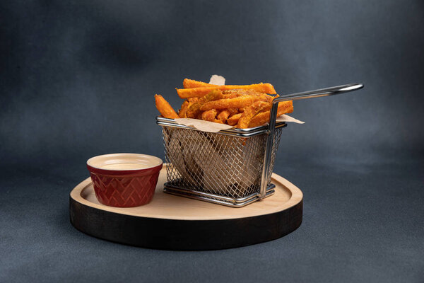 Картошка фри с соусом на деревянной доске