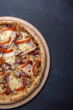 İtalyan mutfağı. Koyu arkaplanda lezzetli bir pizza.