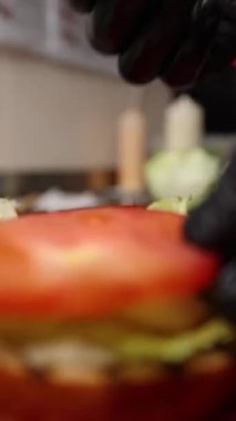 Şef lezzetli bir hamburger hazırlar..