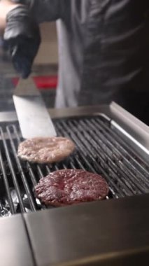 Şef lezzetli bir hamburger hazırlar..