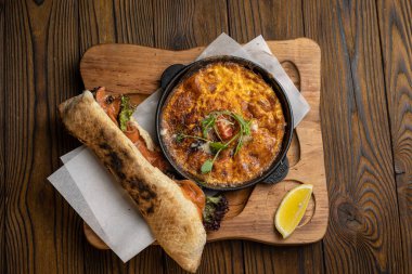 Tahta bir masa ve sandviçle domatesli, sebzeli lezzetli bir omlet. 