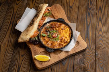 Tahta bir masa ve sandviçle domatesli, sebzeli lezzetli bir omlet. 