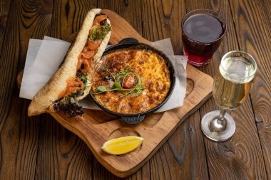 Tahta bir masa ve sandviçle domatesli, sebzeli lezzetli bir omlet. 