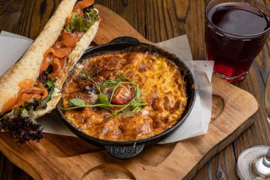 Tahta bir masa ve sandviçle domatesli, sebzeli lezzetli bir omlet. 