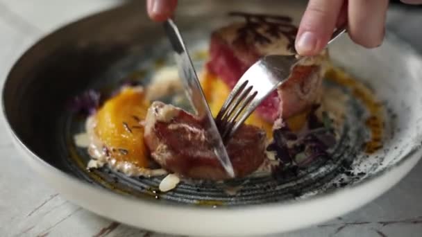 레스토랑에서 접시에 메달에 맛있는 스테이크를 자르십시오 — 비디오