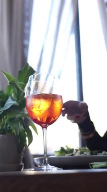 Kızın elinde bir aperol.