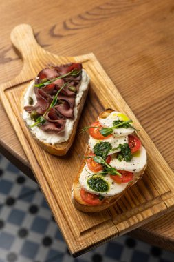 Ahşap bir masada Jamon ve peynirli lezzetli bruschetta.