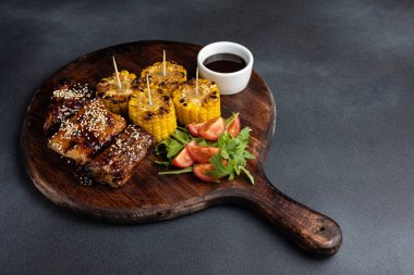 Kızarmış dana kaburgası ve koçanında kızarmış mısır.