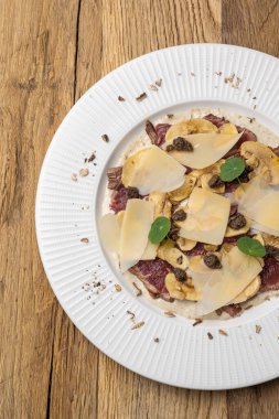 Tahta masada parmesanlı dana carpaccio.