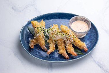 Mavi tabakta karides tempurası. Beyaz arkaplan, kapat