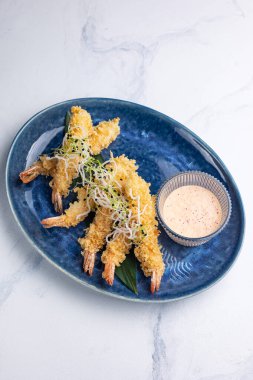 Mavi tabakta karides tempurası. Beyaz arkaplan, kapat