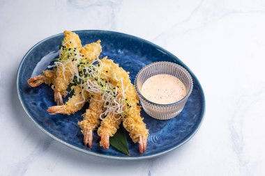 Mavi tabakta karides tempurası. Beyaz arkaplan, kapat