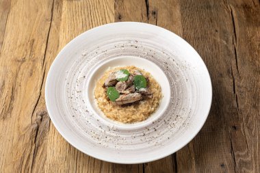 Tahta bir masada kuzu filetosu ile risotto..