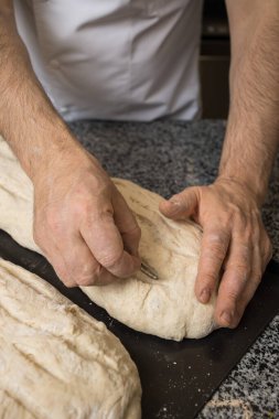 Fırıncı ekmek pişirmek için ekmek hazırlar.