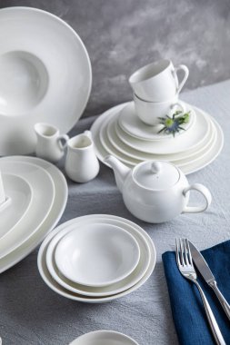 Tabaklar, tabaklar, bardaklar, kaşıklar ve çatallar mutfakta.