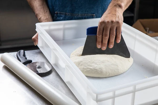 Bir fırıncı mutfakta ekmek hazırlar.