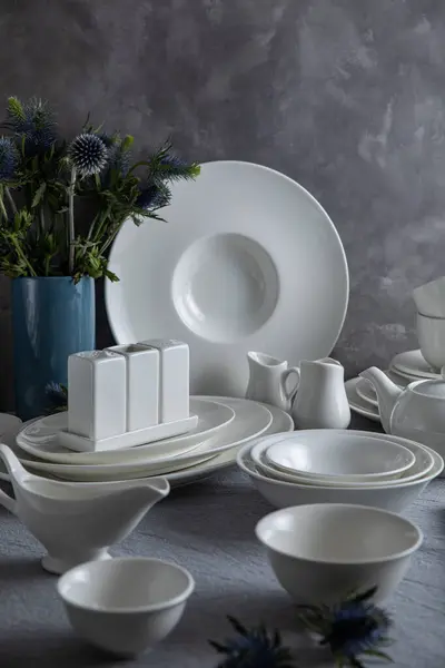 Tabaklar, tabaklar, bardaklar, kaşıklar ve çatallar mutfakta.