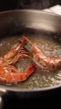 Kızartma tavasında baharatla tereyağında kızartılmış kaplan karidesi.