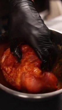 Şef domuz etini baharatla marine eder.