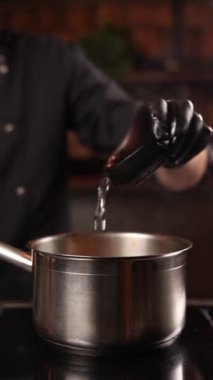 Şef domuz etini baharatla marine eder.