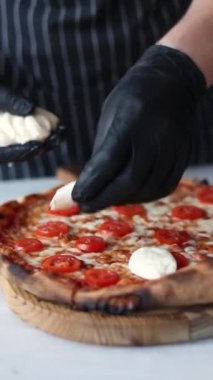 Mozzarella, pesto sosu ve vişneli domates soslu pizza.