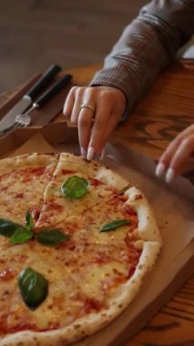Bir bayan pizzacıda pizzanın tadını çıkarmak üzere.