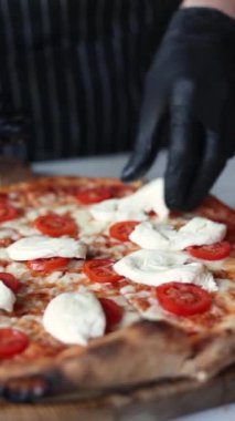 Mozzarella, pesto sosu ve vişneli domates soslu pizza.