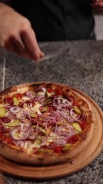 Şef lezzetli pizzalar pişiriyor.