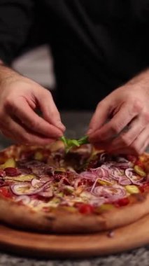 Şef lezzetli pizzalar pişiriyor.