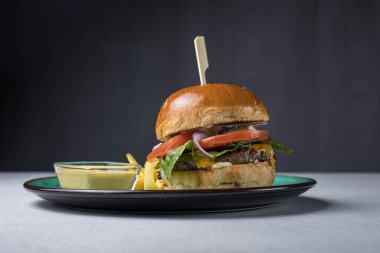 Peynirli, sebzeli ve pirzolalı lezzetli hamburger.