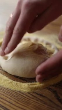 Şef sosisli, peynirli, domatesli pizza pişirir.