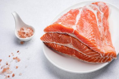 Beyaz tabakta taze, lezzetli somon filetosu.