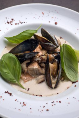 Tabakta bir tabak midye ve fesleğen. Kapat. 