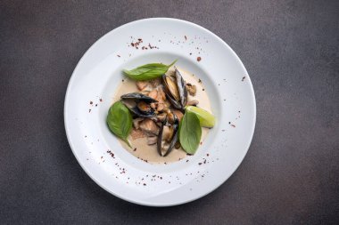 Tabakta bir tabak midye ve fesleğen. Kapat. 