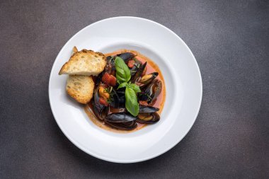 Tabakta bir tabak midye ve fesleğen. Kapat. 