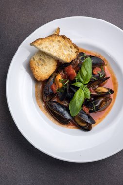 Tabakta bir tabak midye ve fesleğen. Kapat. 