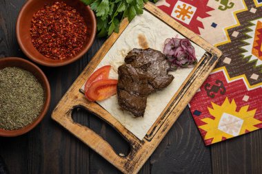 Koyu ahşap masadaki Gürcü et yemekleri. 