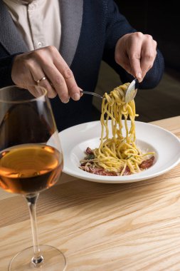 Pastırmalı spagetti ve beyaz tabakta parmesan peyniri.