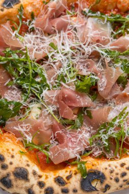 Prosciutto, roka ve parmesanlı pizza.