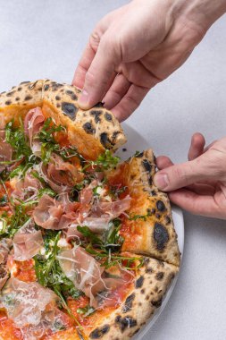 Prosciutto, roka ve parmesanlı pizza.