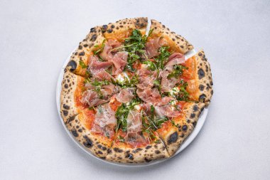 Prosciutto, roka ve parmesanlı pizza.