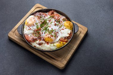 Pastırmalı yumurta ve tavada bitki. 