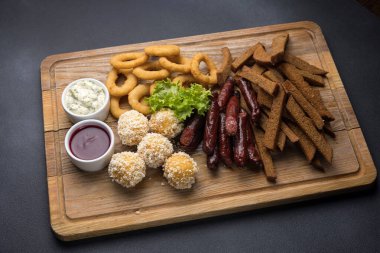 Tahtada sosisli, peynirli ve krakerli abur cuburlar