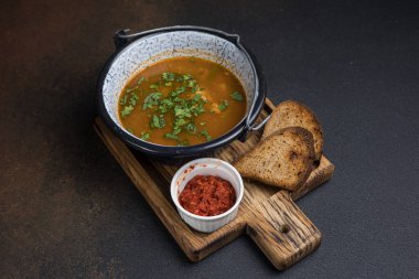 Karanlık bir arka planda et ve sebzeli çorba.