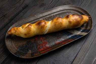 Geleneksel Türk ekmeği pidesi ve ahşap arka planda baharatlar.